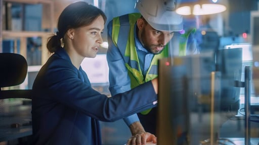 Web_Desktop-Modern Factory Office_ Male Project Manager Talks to a Female Industrial Engineer who Works on Computer. Professional Teamwork, Specialists Solving Problems, Finding Solutions
